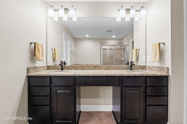 full bathroom with double vanity, a sink, and a shower stall