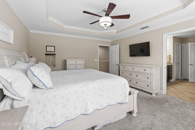 bedroom featuring ornamental molding, visible vents, a raised ceiling, and light colored carpet