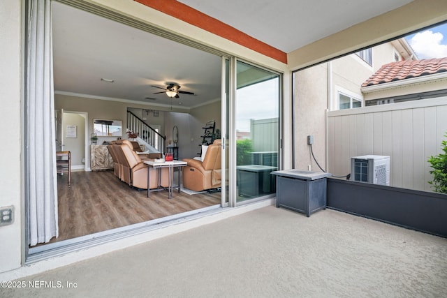 interior space with a wealth of natural light, crown molding, stairway, and ceiling fan