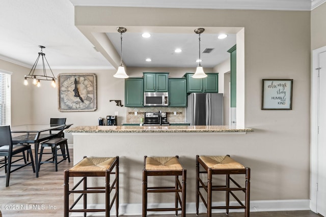 kitchen with green cabinetry, visible vents, appliances with stainless steel finishes, tasteful backsplash, and crown molding