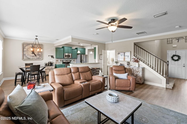 living area featuring stairs, visible vents, wood finished floors, and ornamental molding