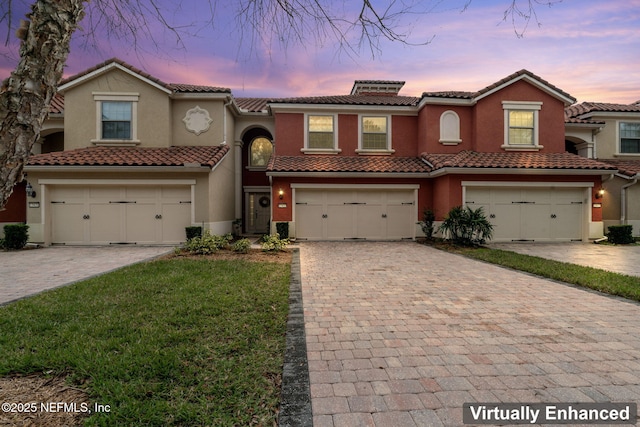 view of front facade with a garage, decorative driveway, and stucco siding