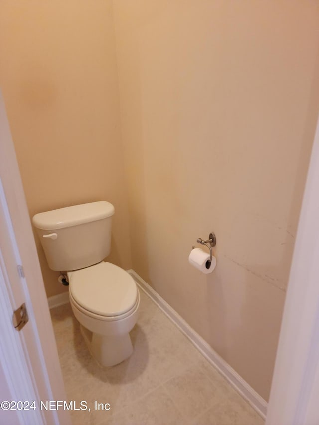 bathroom with toilet, tile patterned flooring, and baseboards