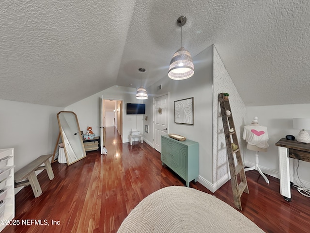 bonus room with lofted ceiling, a textured ceiling, wood finished floors, and baseboards