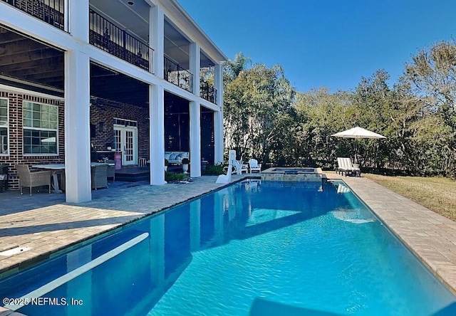 view of pool with a pool with connected hot tub, french doors, and a patio