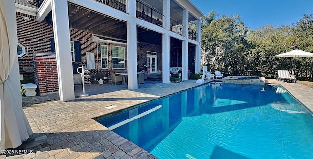 view of swimming pool with a patio area and a pool with connected hot tub