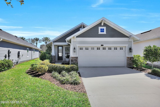 craftsman house featuring a front yard, an attached garage, stone siding, and driveway