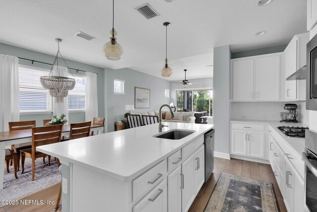 kitchen featuring visible vents, stainless steel appliances, a sink, light countertops, and light wood-type flooring