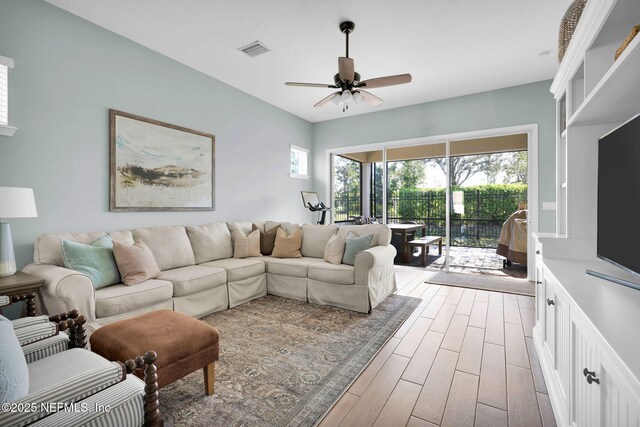 living area featuring wood finished floors, visible vents, and ceiling fan