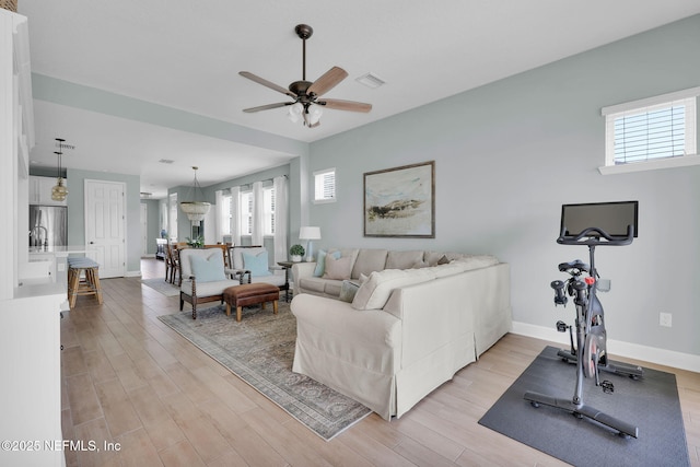 living area with visible vents, baseboards, and light wood-style flooring