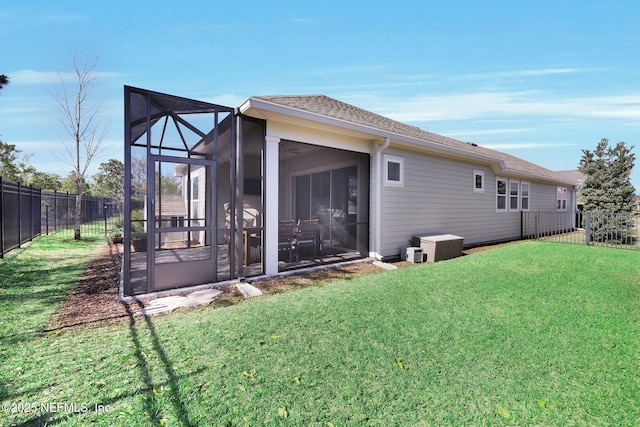 back of property with a yard, a fenced backyard, and a shingled roof