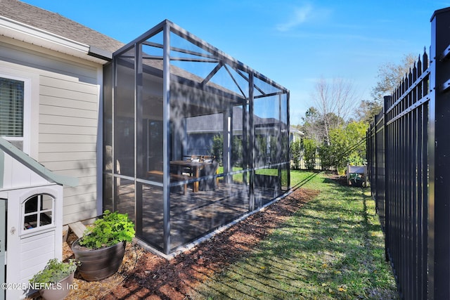 view of yard with a lanai and fence