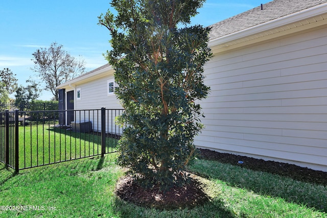 view of home's exterior featuring a lawn and fence