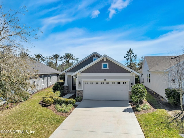 view of front of home featuring stone siding, a front lawn, concrete driveway, and an attached garage