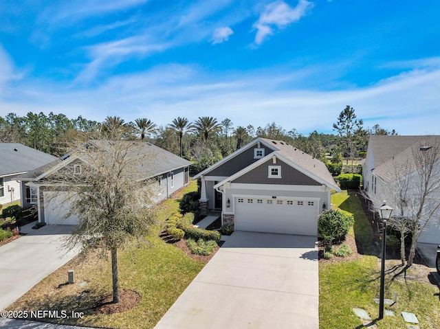 view of front of property featuring stone siding, an attached garage, concrete driveway, and a front lawn