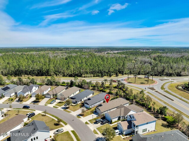 drone / aerial view featuring a residential view and a wooded view