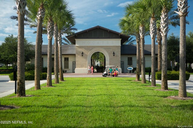 rear view of house featuring a yard and stucco siding