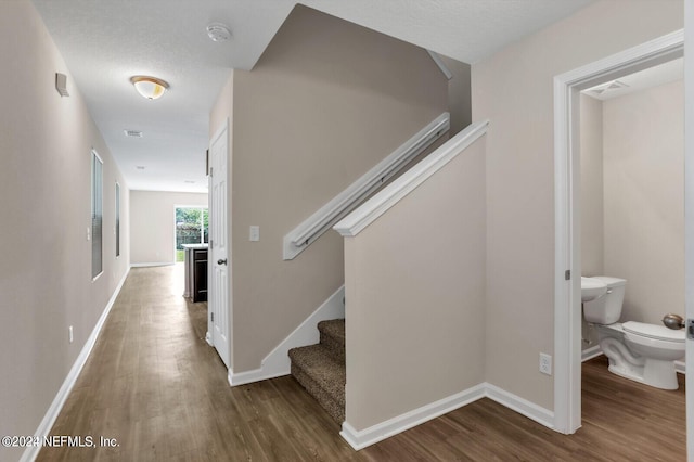 hall featuring stairway, wood finished floors, and baseboards