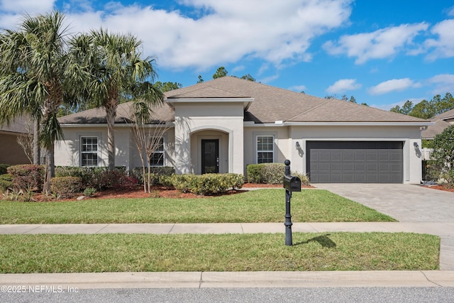 view of front of house with stucco siding, a shingled roof, an attached garage, driveway, and a front lawn