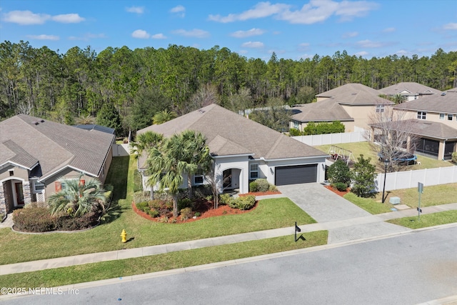 single story home with a garage, fence, decorative driveway, and a front yard