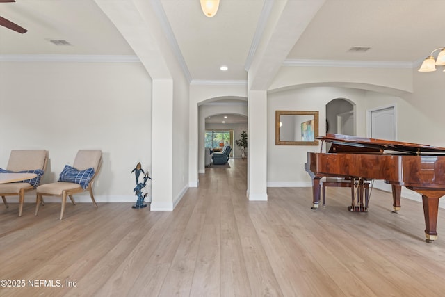 foyer featuring visible vents, crown molding, light wood-style flooring, and baseboards