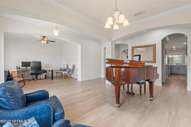 sitting room featuring arched walkways, visible vents, baseboards, ornamental molding, and light wood finished floors