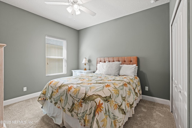 bedroom featuring light carpet, baseboards, and a textured ceiling