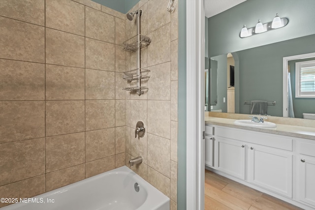 full bath with shower / washtub combination, wood finished floors, and vanity