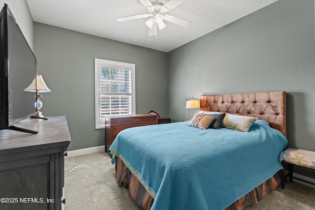 bedroom featuring light carpet, ceiling fan, baseboards, and a textured ceiling