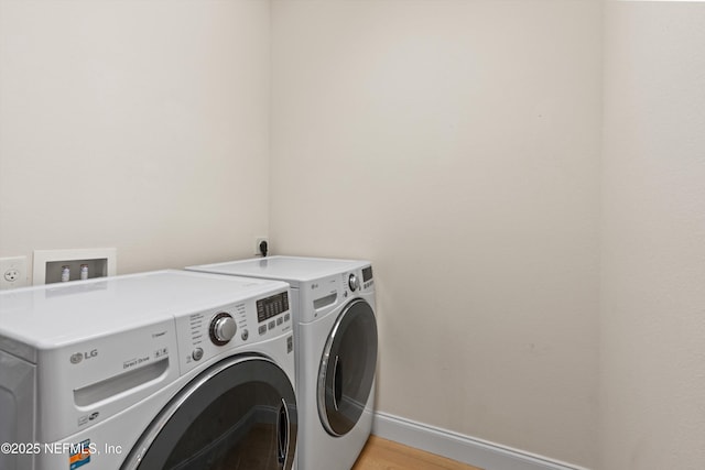 laundry area with laundry area, light wood-style flooring, baseboards, and separate washer and dryer