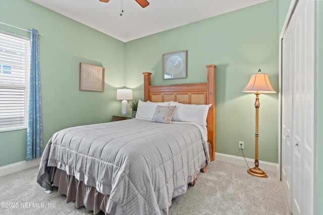 bedroom featuring light carpet, ceiling fan, a closet, and baseboards