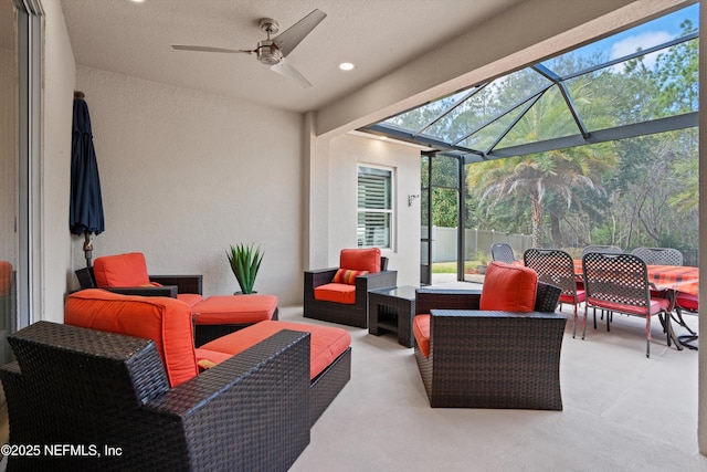 view of patio with glass enclosure, outdoor lounge area, fence, a ceiling fan, and outdoor dining space