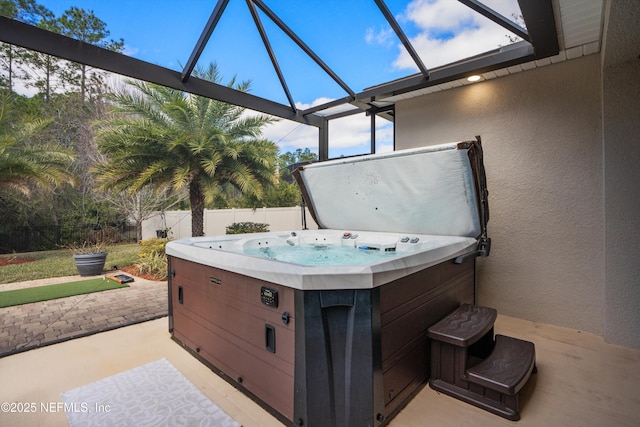 view of patio / terrace featuring a hot tub and fence