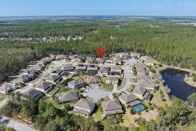 birds eye view of property with a water view, a residential view, and a wooded view