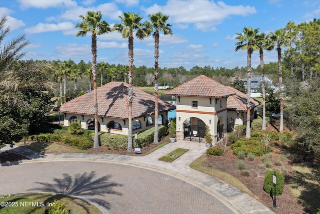 view of front of home featuring a tiled roof, driveway, and stucco siding