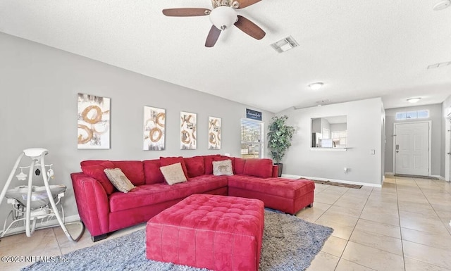 living area with baseboards, visible vents, a textured ceiling, and light tile patterned flooring