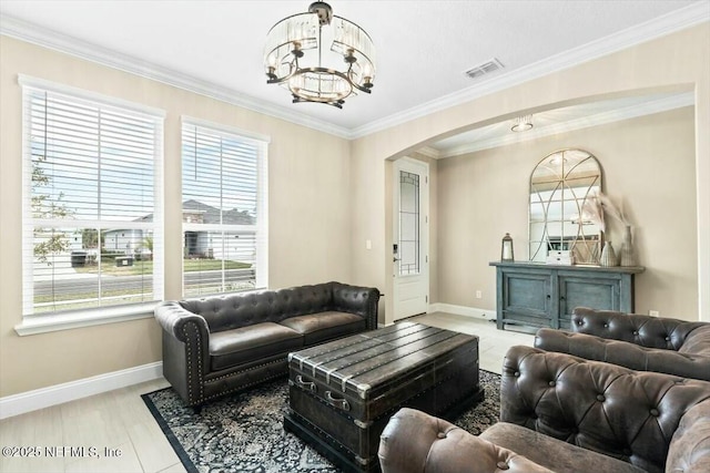 living area with arched walkways, visible vents, crown molding, and baseboards