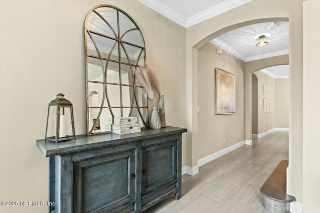 hall featuring ornamental molding, arched walkways, and baseboards