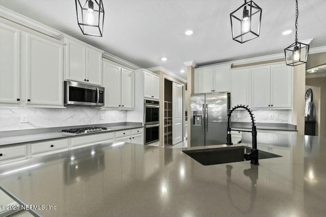 kitchen with decorative backsplash, appliances with stainless steel finishes, crown molding, white cabinetry, and a sink