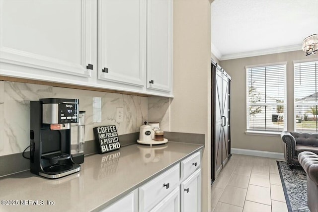 kitchen with plenty of natural light, white cabinetry, crown molding, and decorative backsplash