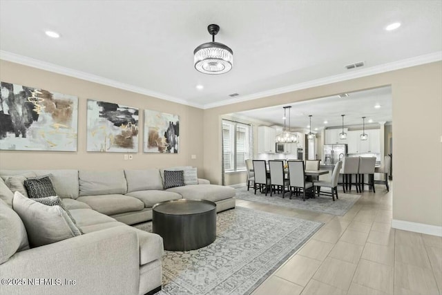 living area featuring a chandelier, visible vents, ornamental molding, and baseboards