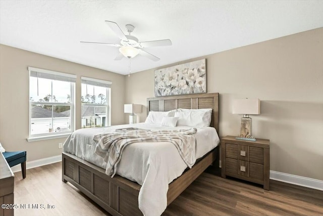 bedroom featuring ceiling fan, baseboards, and wood finished floors