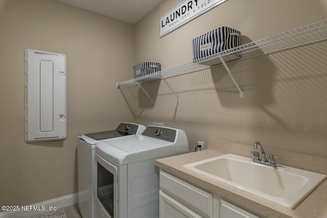 washroom featuring a sink, baseboards, independent washer and dryer, cabinet space, and electric panel