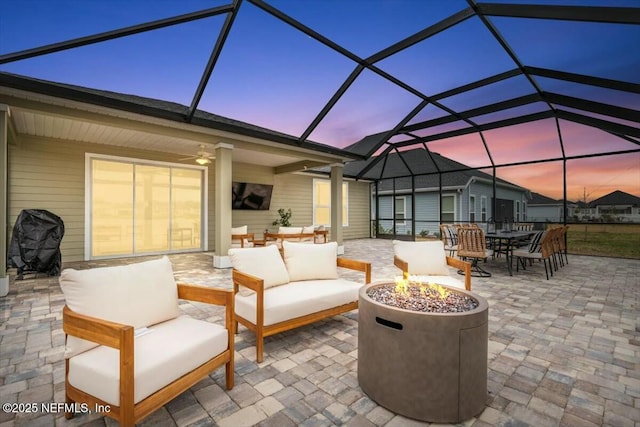 view of patio featuring outdoor dining space, a lanai, and an outdoor living space with a fire pit