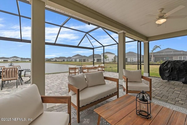 view of patio with glass enclosure, outdoor lounge area, a water view, and grilling area