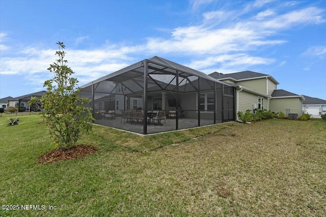 back of house featuring a patio area, glass enclosure, and a lawn