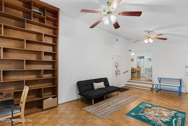 living area with ceiling fan and baseboards