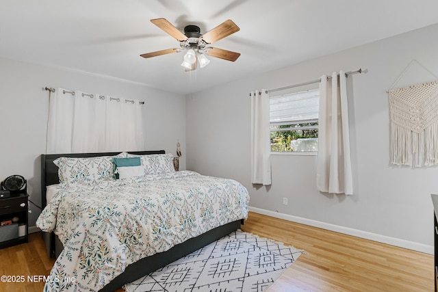 bedroom featuring a ceiling fan, baseboards, and wood finished floors