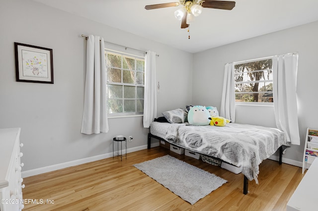 bedroom featuring a ceiling fan, baseboards, and wood finished floors