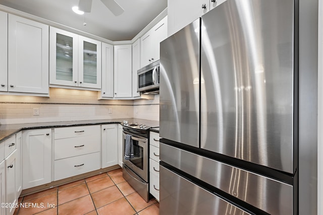 kitchen featuring appliances with stainless steel finishes, white cabinetry, backsplash, and light tile patterned floors